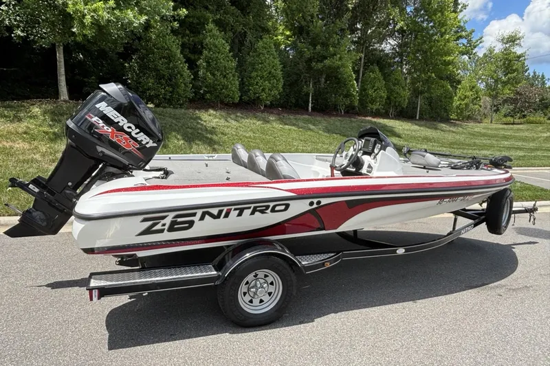 Slide: The Image of 2014 Nitro Z-6 boat with Mercury engine on trailer, parked on a road. - 17