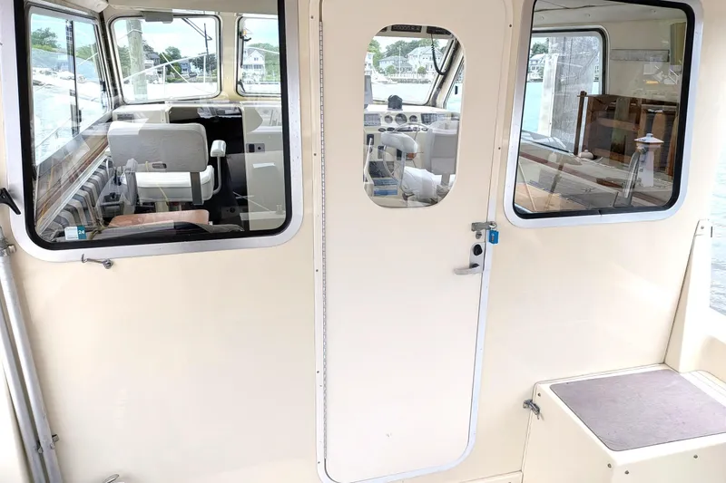 Slide: The Image of Interior view of 2003 Atlas Acadia 32 boat, showcasing helm and seating area. - 10