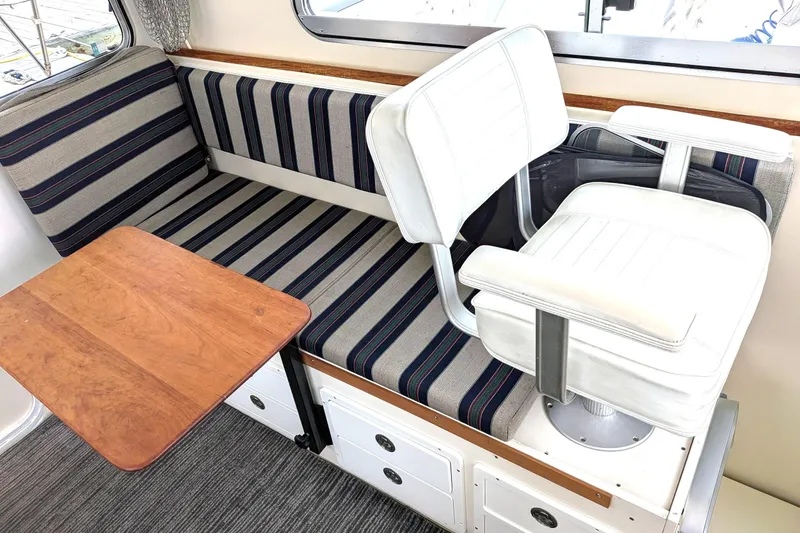 Slide: The Image of Interior of 2003 Atlas Acadia 32 boat with striped seating and wooden table. - 20