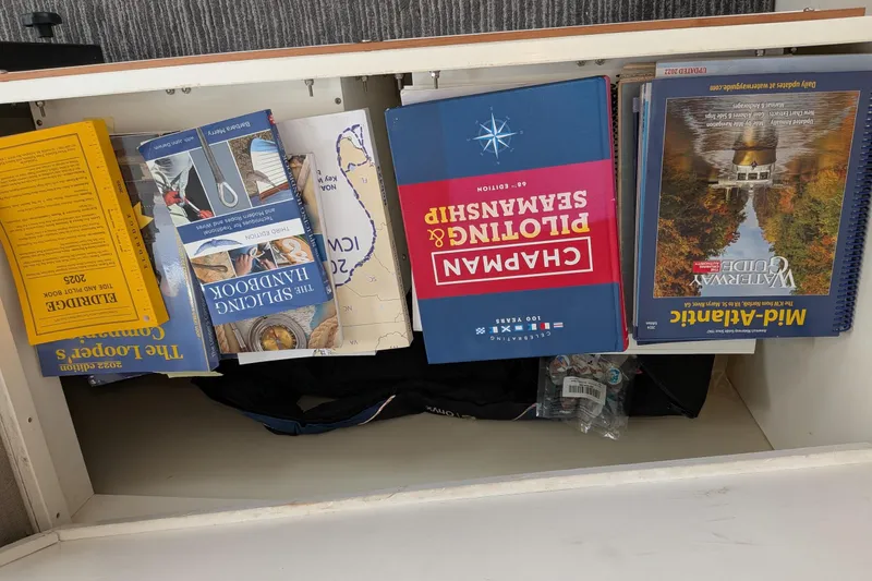 Slide: The Image of Books and guides in a drawer, including "Chapman Piloting & Seamanship" and "The Splicing Handbook." - 21