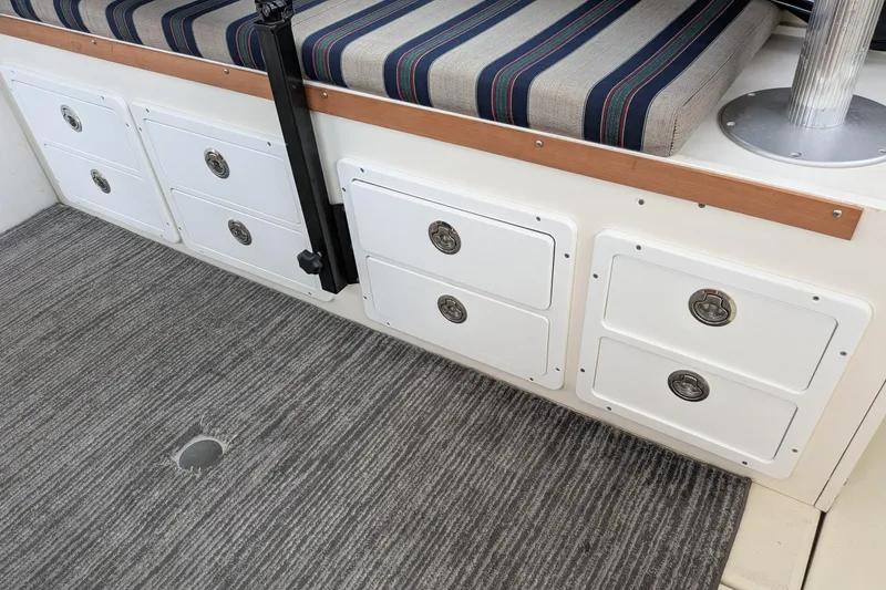 Slide: The Image of Interior of 2003 Atlas Acadia 32 boat with striped seating and storage drawers. - 22