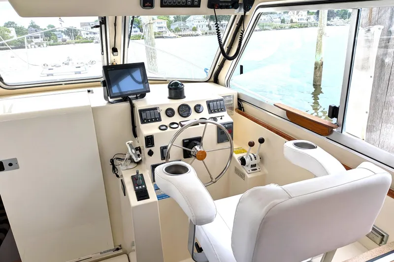 Slide: The Image of Interior helm of 2003 Atlas Acadia 32 boat with steering wheel and navigation equipment. - 24