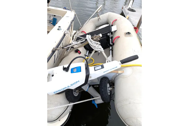 Slide: The Image of Electric outboard motor on inflatable boat beside Atlas Acadia 32, 2003 model, at dock. - 3