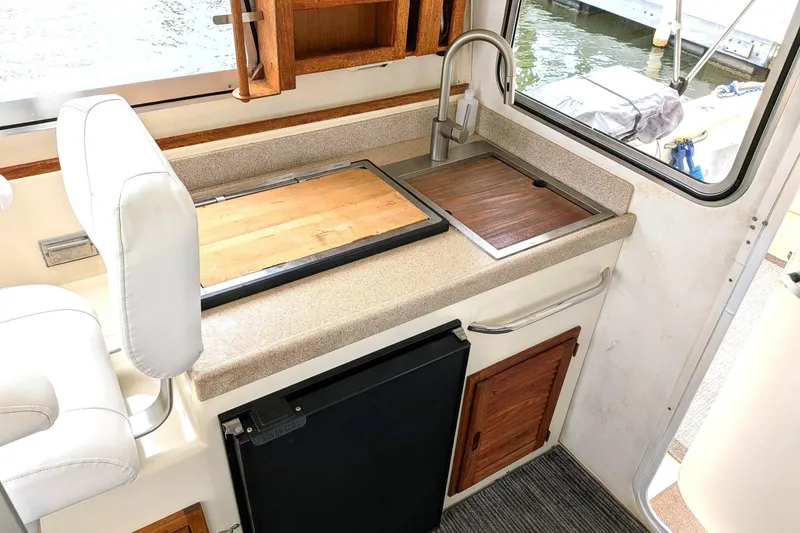 Slide: The Image of Compact kitchen area in a 2003 Atlas Acadia 32 boat with sink and countertop. - 30