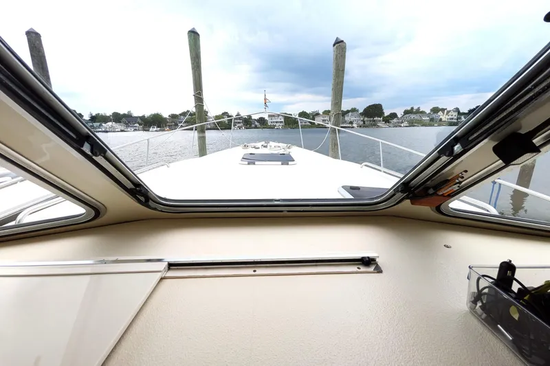 Slide: The Image of View from inside a 2003 Atlas Acadia 32 boat, overlooking a serene waterfront. - 33