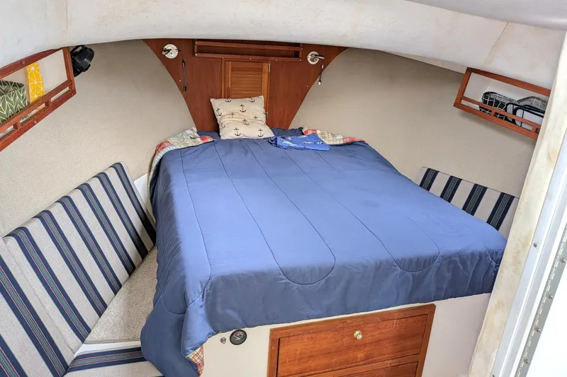 Slide: The Image of Cozy cabin interior of 2003 Atlas Acadia 32 boat with blue bedding and striped seating. - 34