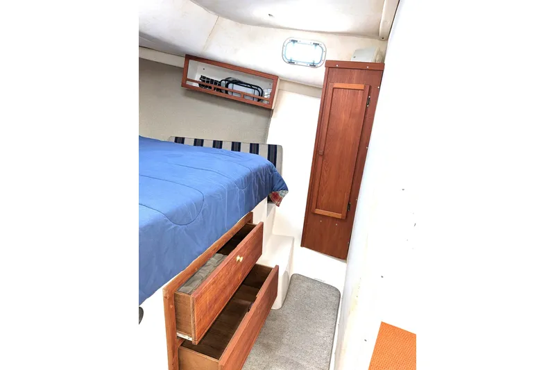 Slide: The Image of Interior cabin of 2003 Atlas Acadia 32 boat with bed and wooden storage. - 35