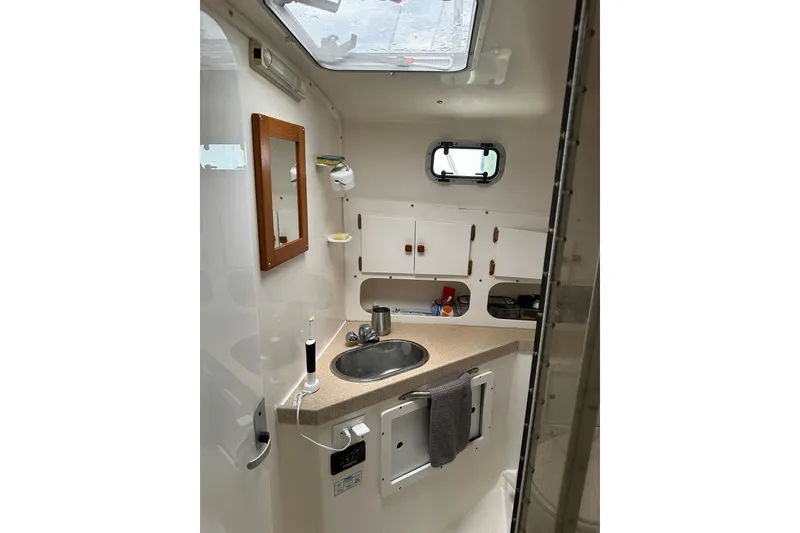 Slide: The Image of Compact bathroom interior of 2003 Atlas Acadia 32 boat with sink and storage cabinets. - 38