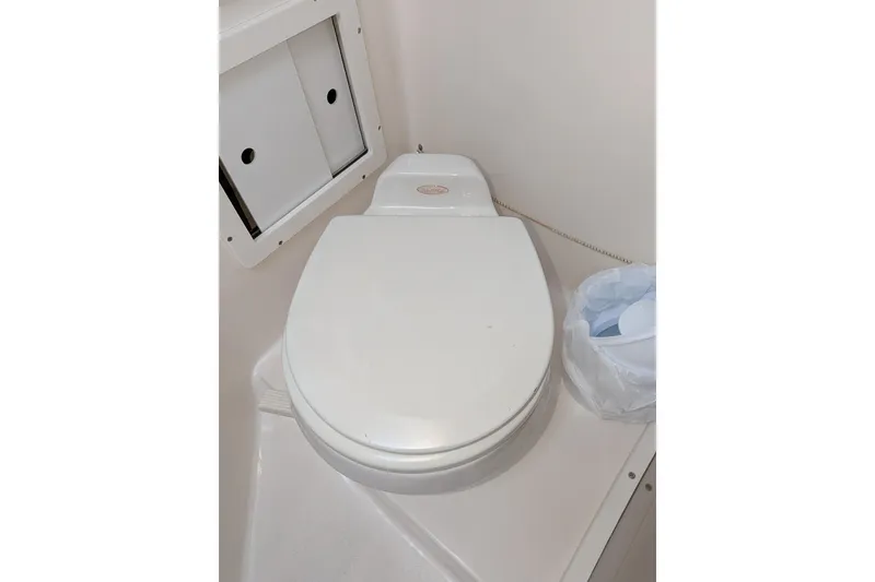 Slide: The Image of Toilet in 2003 Atlas Acadia 32 boat bathroom, with storage compartment and waste bin. - 39