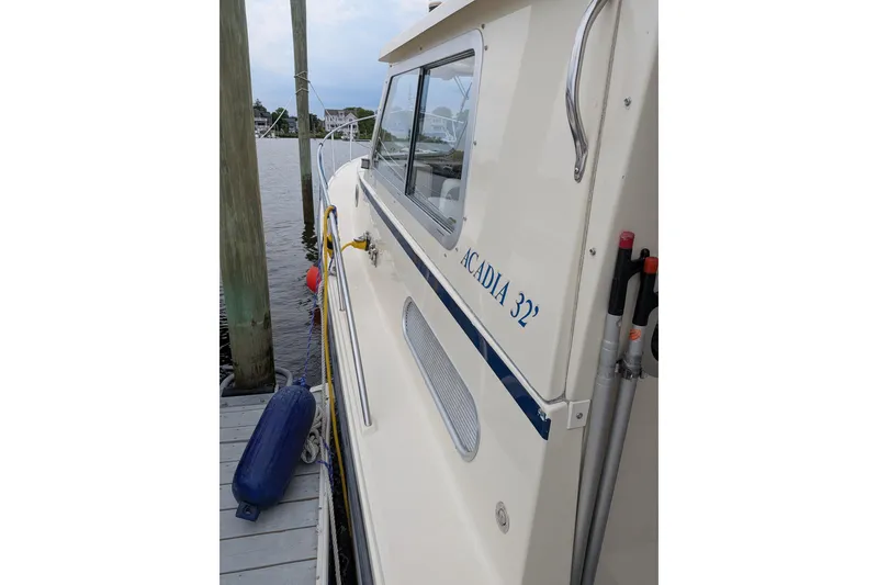 Slide: The Image of 2003 Atlas Acadia 32 boat docked, side view with visible name and equipment. - 40
