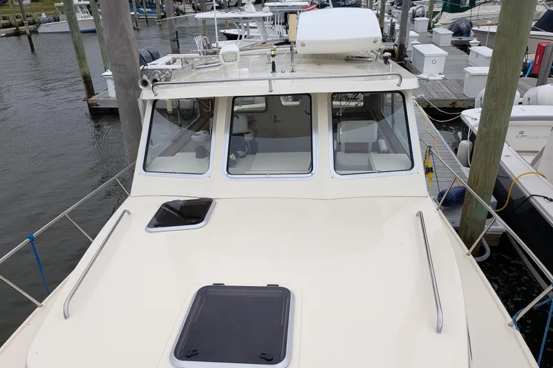 Slide: The Image of 2003 Atlas Acadia 32 boat docked at marina, featuring spacious cabin and sleek design. - 43