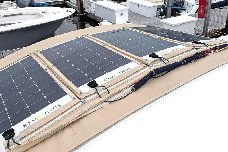 Slide: The Image of Solar panels on a 2003 Atlas Acadia 32 boat, docked at a marina. - 45