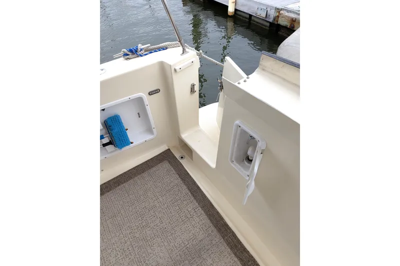 Slide: The Image of Atlas Acadia 32 boat deck, 2003 model, featuring storage compartments and dockside view. - 6