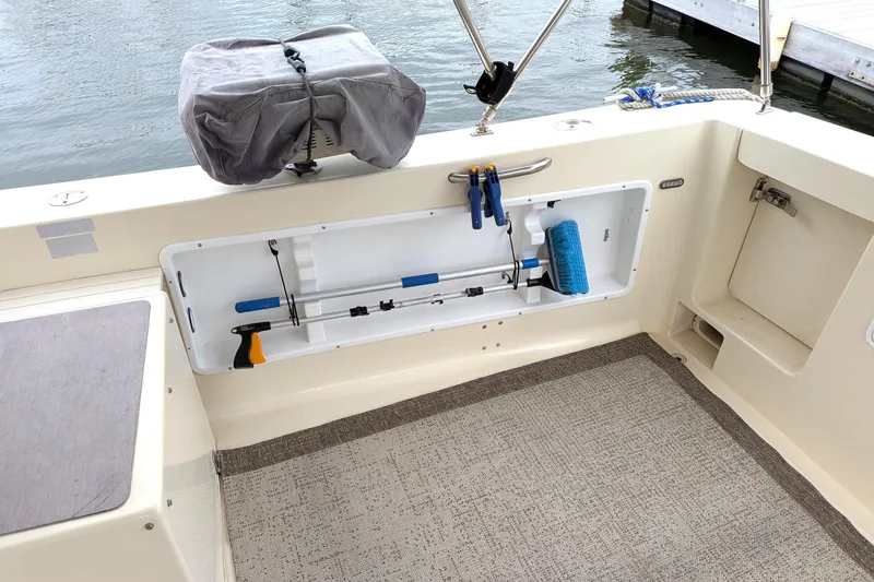 Slide: The Image of 2003 Atlas Acadia 32 boat deck with storage compartment and cleaning tools. - 8