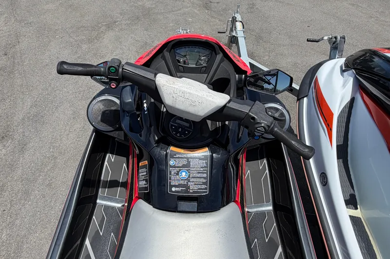 Slide: The Image of 2024 Kawasaki Jetski STX 160LX handlebars and dashboard, parked on pavement. - 11