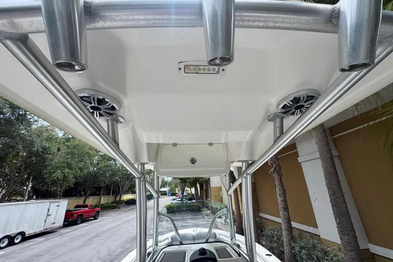 Slide: The Image of 2017 Sea Fox 226 Commander boat with T-top and rod holders, parked outdoors. - 14
