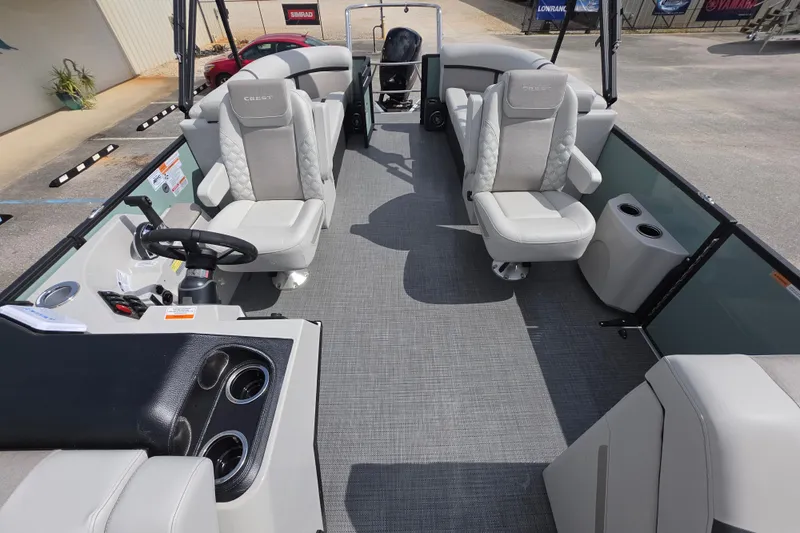 Slide: The Image of 2026 Crest Conquest 235 SLC pontoon boat interior with plush seating and modern helm. - 10