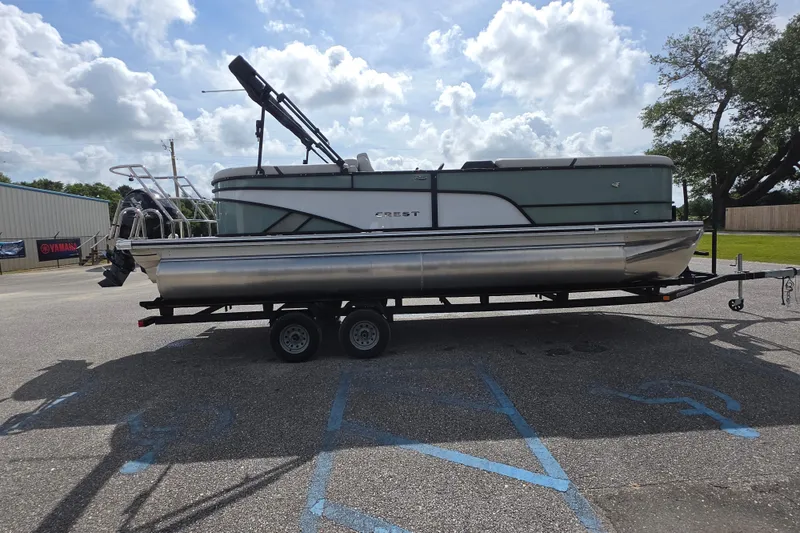 Slide: The Image of 2026 Crest Conquest 235 SLC pontoon boat on trailer under cloudy sky. - 6