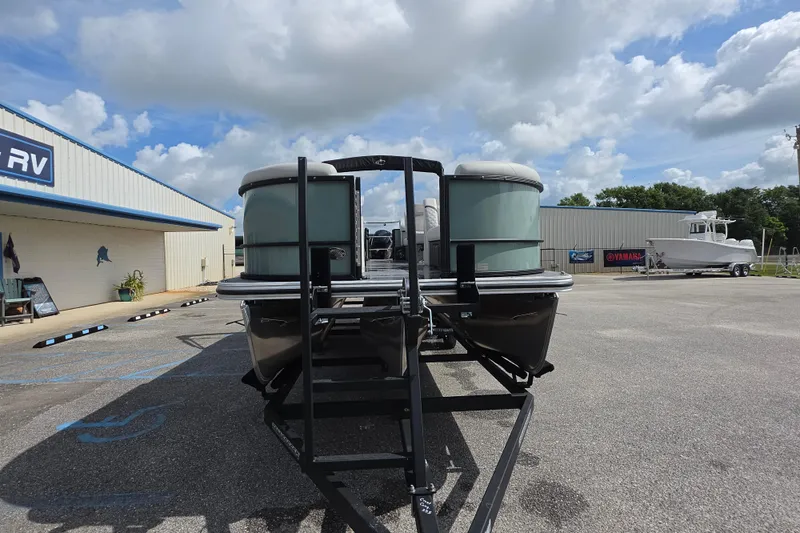 Slide: The Image of 2026 Crest Conquest 235 SLC pontoon boat on trailer at dealership under cloudy sky. - 3