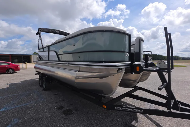 Slide: The Image of 2026 Crest Conquest 235 SLC pontoon boat on trailer under cloudy sky. - 4