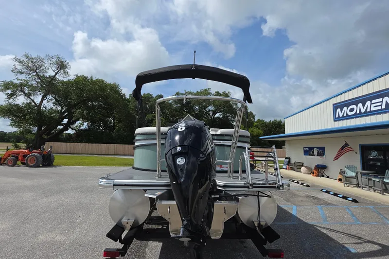 Slide: The Image of 2026 Crest Conquest 235 SLC pontoon boat with outboard motor, parked near dealership. - 8
