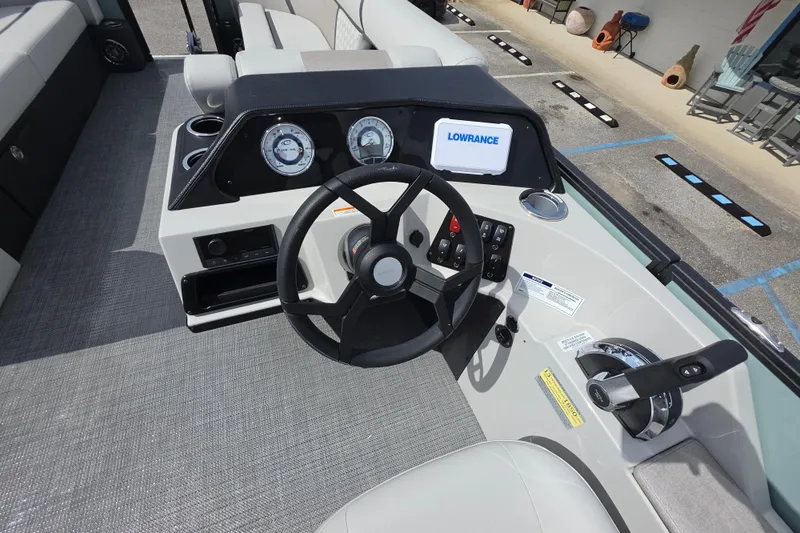 Slide: The Image of 2026 Crest Conquest 235 SLC boat dashboard with steering wheel and Lowrance display. - 17