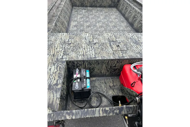Slide: The Image of 2025 Tracker Grizzly 1860 AWL boat interior with camouflage design, battery, and red fuel tank. - 5