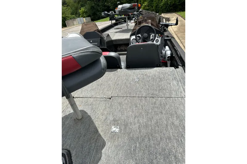 Slide: The Image of 1988 Aries Bass boat interior with steering console and seating, featuring gray and red upholstery. - 3