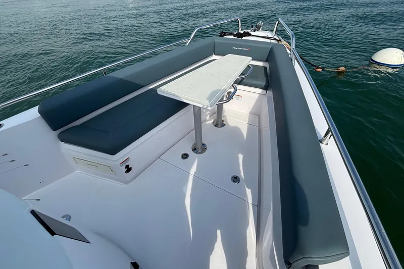 Slide: The Image of 2022 Axopar 28 Cabin boat with spacious seating and table on deck. - 11