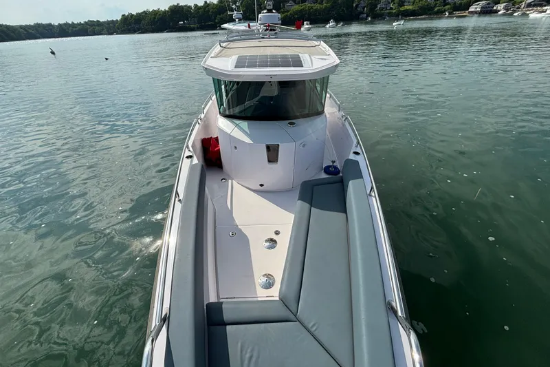Slide: The Image of 2022 Axopar 28 Cabin boat on calm water, featuring sleek design and spacious deck. - 13