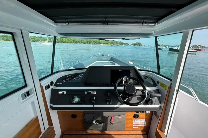 Slide: The Image of Interior view of 2022 Axopar 28 Cabin boat, featuring modern dashboard and steering wheel. - 18