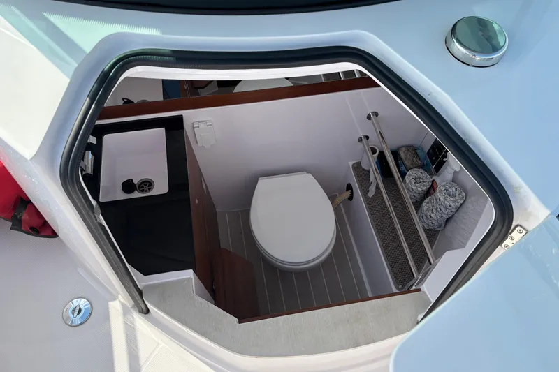 Slide: The Image of 2022 Axopar 28 Cabin boat interior with compact bathroom and sink. - 27