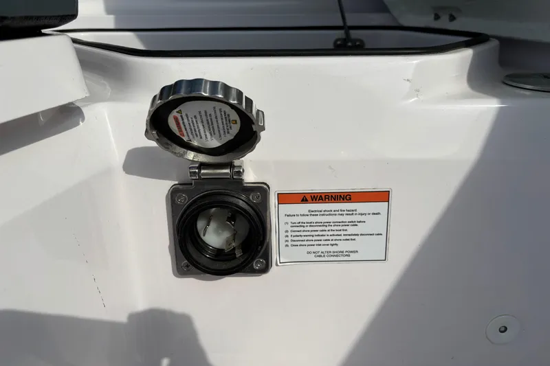 Slide: The Image of Axopar 28 Cabin 2022 boat power connector with warning label, emphasizing safety instructions. - 32