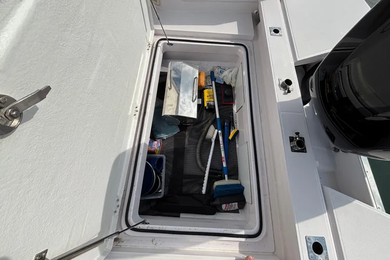 Slide: The Image of Storage compartment of 2022 Axopar 28 Cabin boat with cleaning supplies and tools. - 35