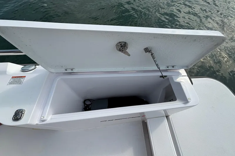 Slide: The Image of Open storage compartment on 2022 Axopar 28 Cabin boat, near water. - 38