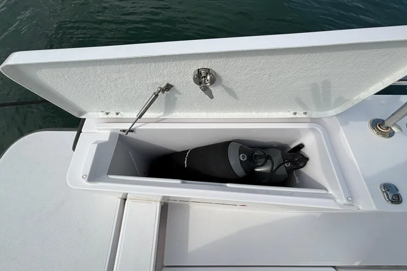 Slide: The Image of Open storage compartment on 2022 Axopar 28 Cabin boat, containing a scuba tank. - 39