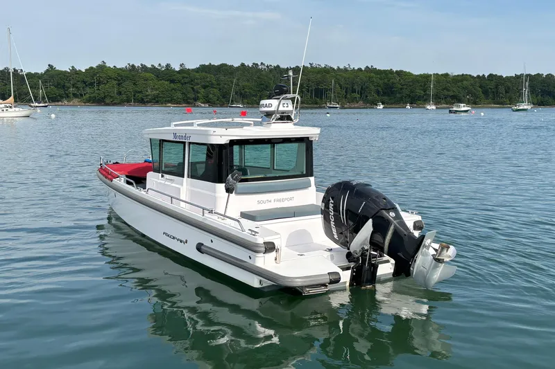 Slide: The Image of 2022 Axopar 28 Cabin boat on calm water, featuring a sleek design and powerful outboard motor. - 6
