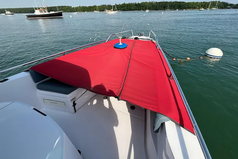 Slide: The Image of 2022 Axopar 28 Cabin boat with red cover on calm water. - 7