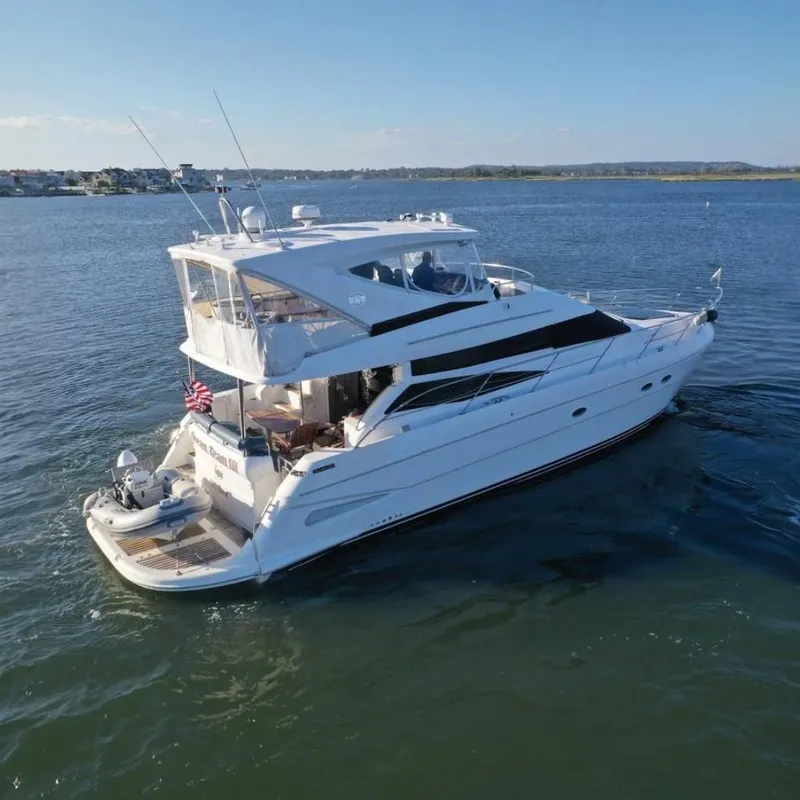 The Image of 2005 Neptunus 56 Flybridge yacht cruising on a serene blue waterway. - 0
