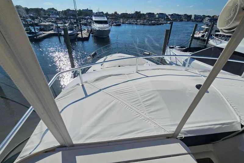 Slide: The Image of 2005 Neptunus 56 Flybridge yacht docked at a marina under sunny skies. - 64