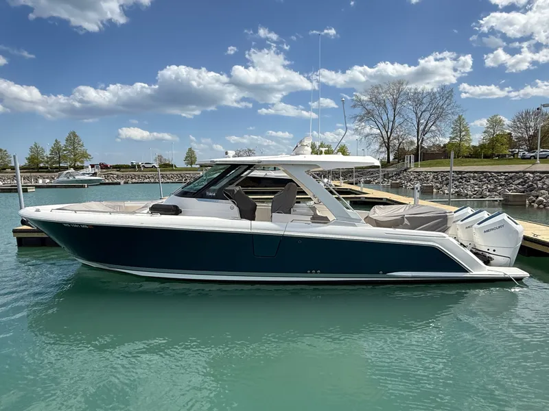 Slide: The Image of Tiara Yachts 38 LS 2024 in a calm harbor with clear water and blue sky. - 1