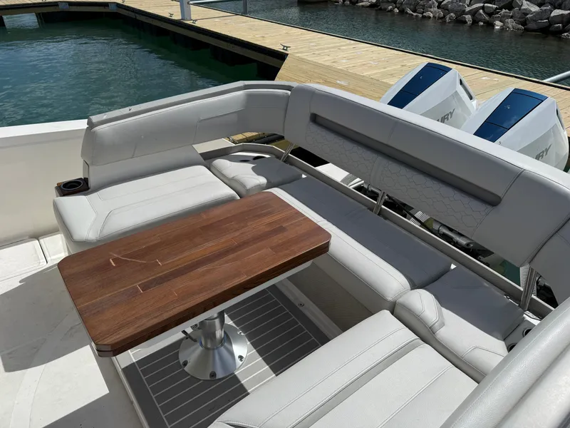 Slide: The Image of The image shows the seating area of a 2024 Tiara Yachts 38 LS with a wooden table. - 11