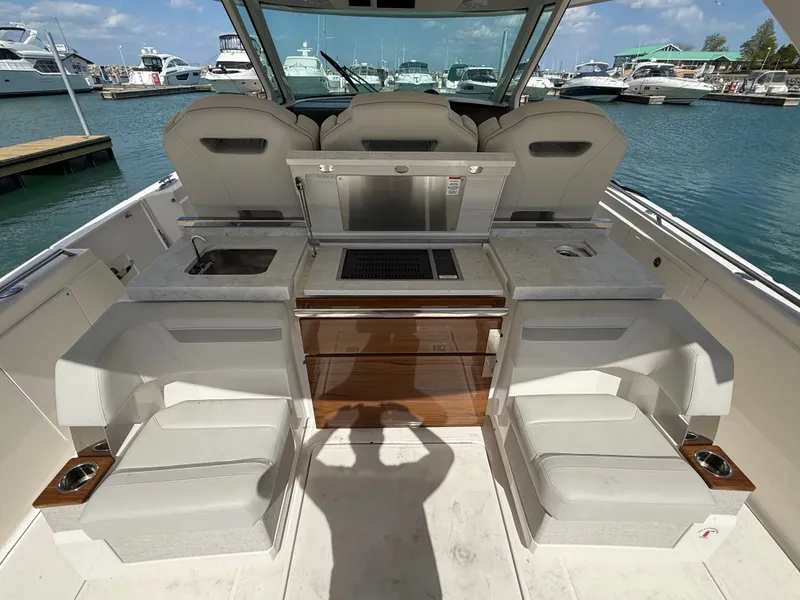 Slide: The Image of Tiara Yachts 38 LS 2024: Luxurious outdoor area with seating and kitchenette at the marina. - 12
