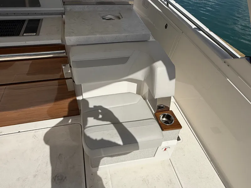 Slide: The Image of Seating area on a 2024 Tiara Yachts 38 LS with white upholstery and wood accents. - 13