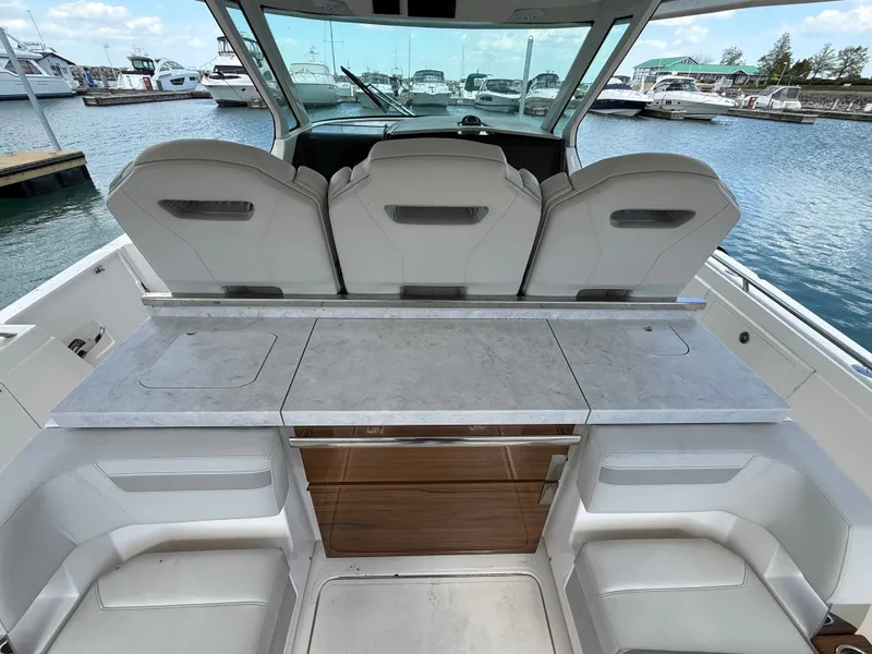 Slide: The Image of 2024 Tiara Yachts 38 LS with a modern cockpit and luxurious features in a marina. - 18