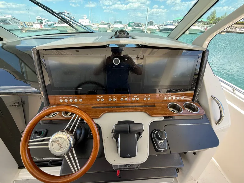 Slide: The Image of Helm of the 2024 Tiara Yachts 38 LS with wood trim and modern steering wheel. - 35