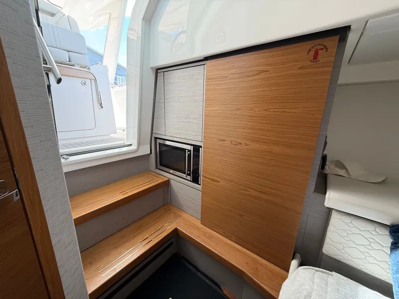 Slide: The Image of Interior of the 2024 Tiara Yachts 38 LS with wood paneling and a microwave. - 42