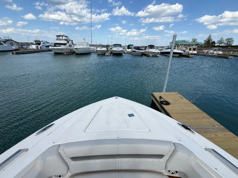Slide: The Image of 2024 Tiara Yachts 38 LS at a marina, surrounded by other boats and a clear sky. - 47