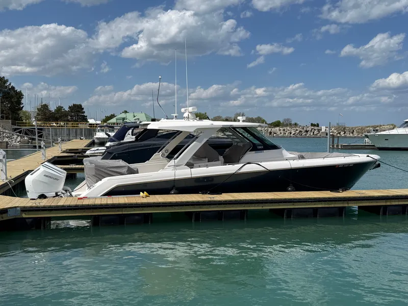 Slide: The Image of 2024 Tiara Yachts 38 LS docked with blue water and a cloudy sky. - 5