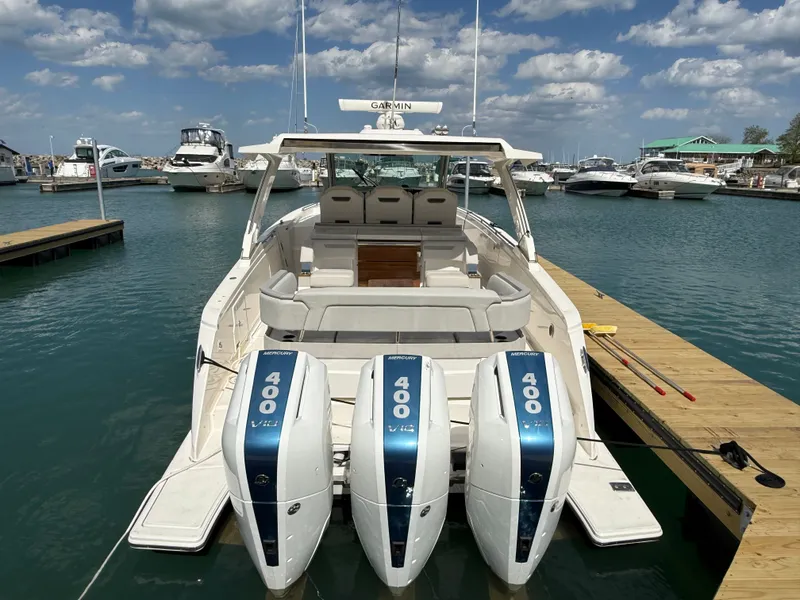 Slide: The Image of 2024 Tiara Yachts 38 LS docked with three outboard engines, surrounded by other boats. - 6